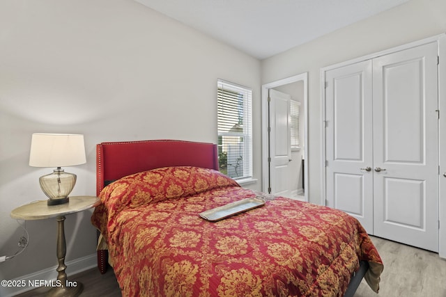 bedroom with light hardwood / wood-style flooring and a closet