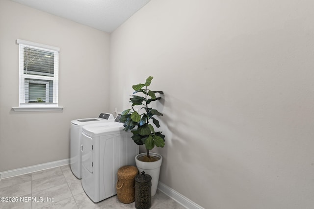 clothes washing area featuring light tile patterned flooring and washer and clothes dryer