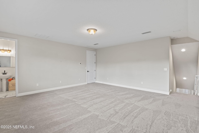 carpeted spare room featuring vaulted ceiling