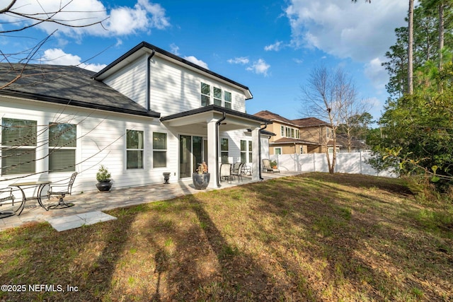 rear view of property featuring a yard and a patio area