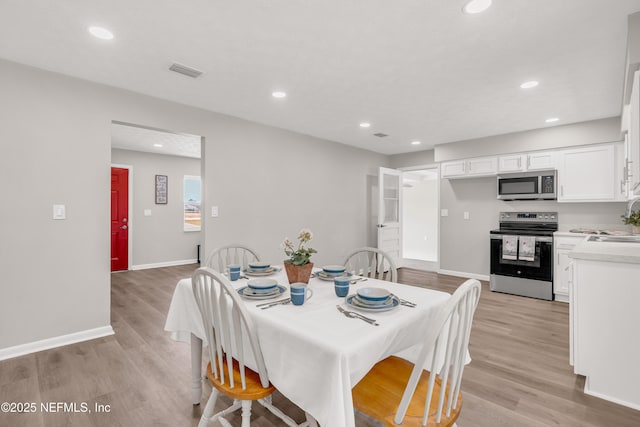 dining room with sink and light hardwood / wood-style flooring