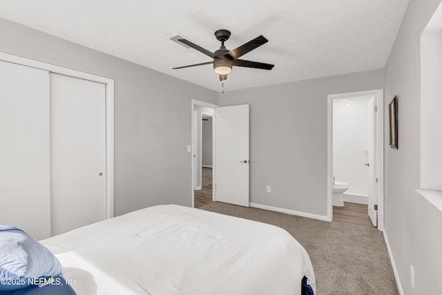 carpeted bedroom featuring ceiling fan, ensuite bath, and a closet