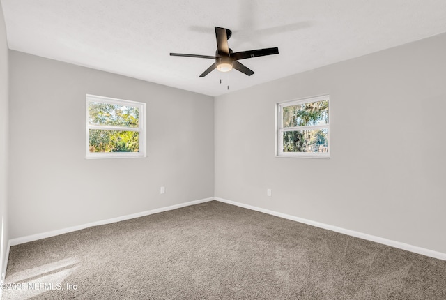 carpeted spare room with ceiling fan