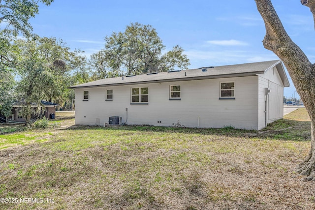 back of house featuring central AC and a lawn