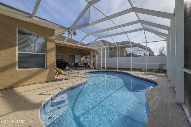 view of swimming pool featuring glass enclosure and a patio area