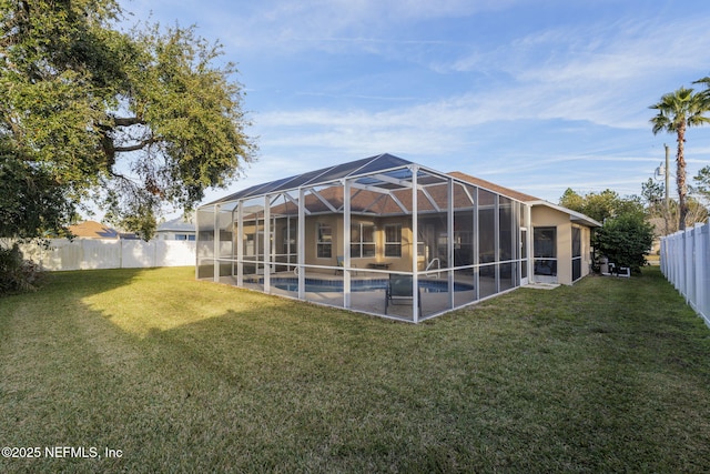 back of property featuring a fenced in pool, a lawn, and glass enclosure