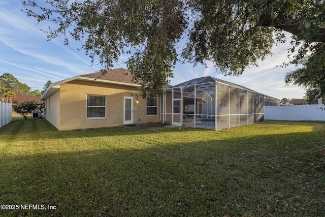 back of house featuring a yard, a lanai, and central air condition unit