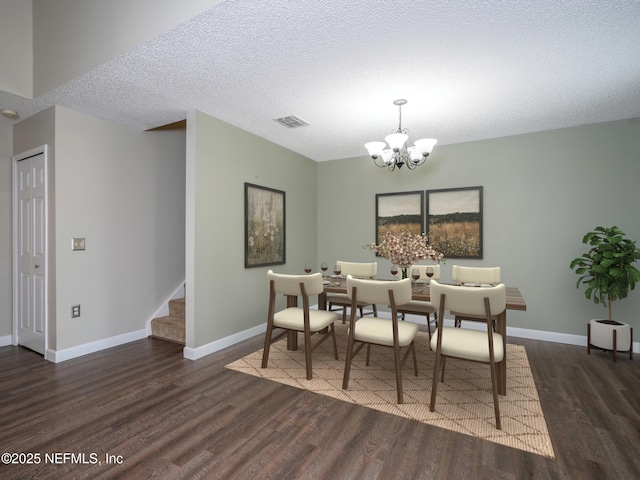 dining space featuring an inviting chandelier, dark hardwood / wood-style floors, and a textured ceiling