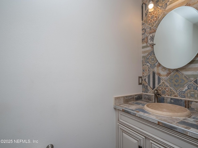 bathroom featuring vanity and backsplash