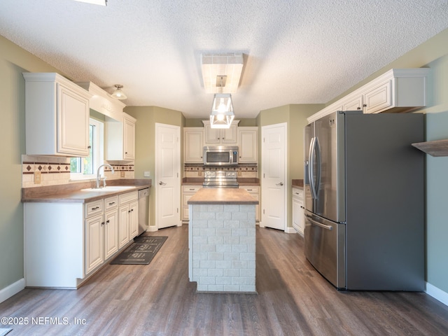 kitchen featuring appliances with stainless steel finishes, sink, a kitchen island, and white cabinets