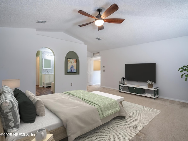 carpeted bedroom featuring ceiling fan, vaulted ceiling, and a textured ceiling