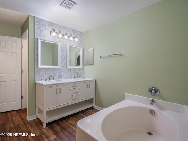 bathroom with hardwood / wood-style flooring, vanity, and a bathtub