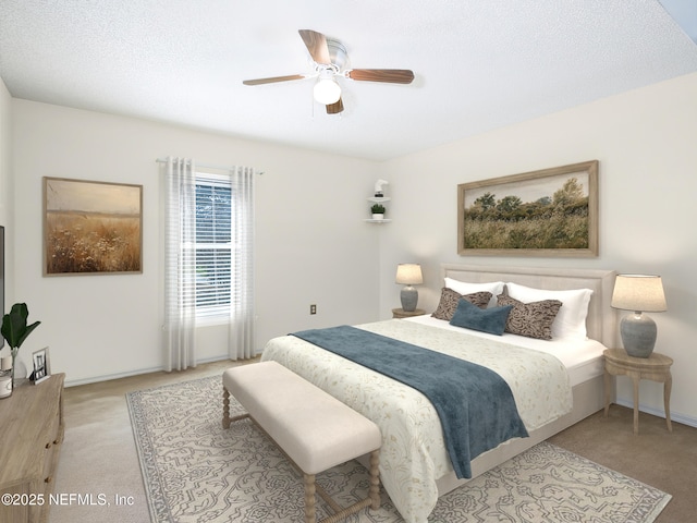 bedroom featuring ceiling fan, light colored carpet, and a textured ceiling