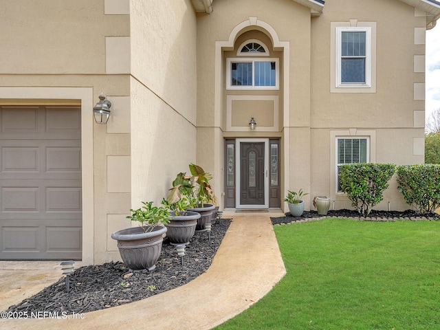 entrance to property featuring a garage and a lawn