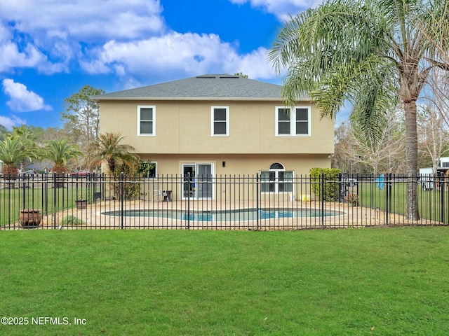 back of property featuring a fenced in pool, a patio, and a lawn