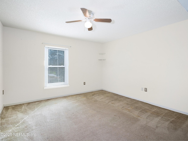 carpeted spare room featuring ceiling fan and a textured ceiling