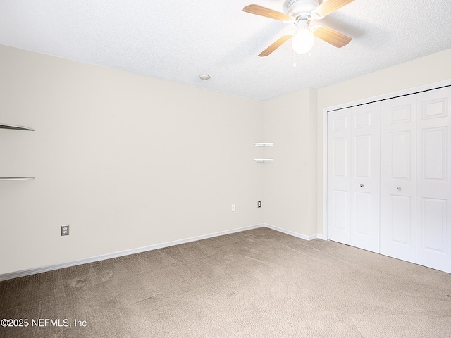 unfurnished bedroom featuring ceiling fan, a closet, carpet flooring, and a textured ceiling