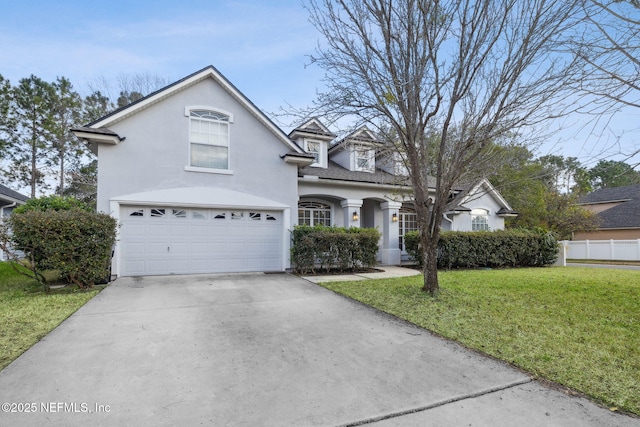 view of property featuring a garage and a front lawn