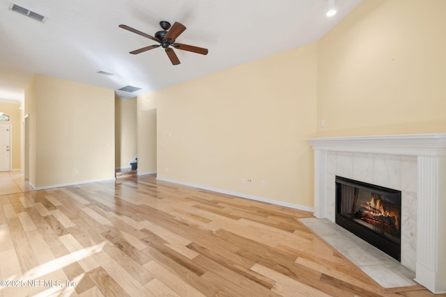 unfurnished living room with light hardwood / wood-style flooring, a fireplace, and ceiling fan