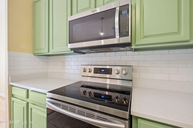 kitchen with tasteful backsplash, appliances with stainless steel finishes, and green cabinetry