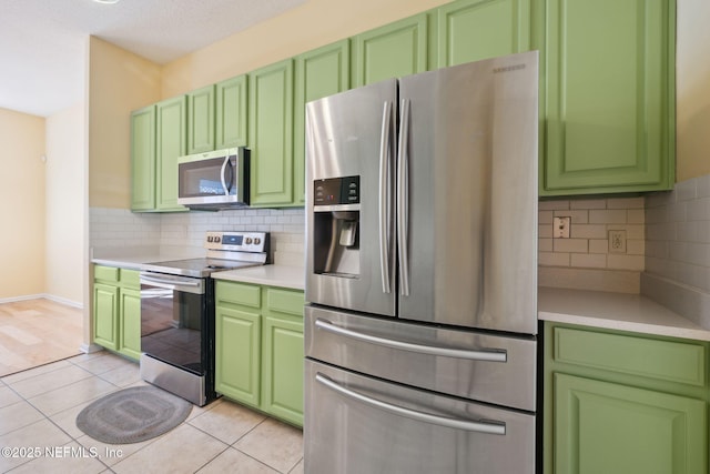 kitchen with light tile patterned floors, decorative backsplash, and appliances with stainless steel finishes