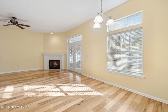 unfurnished living room with plenty of natural light, light hardwood / wood-style floors, and a tile fireplace