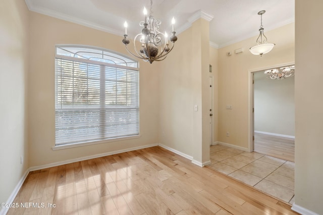 spare room featuring crown molding, a notable chandelier, and light hardwood / wood-style floors