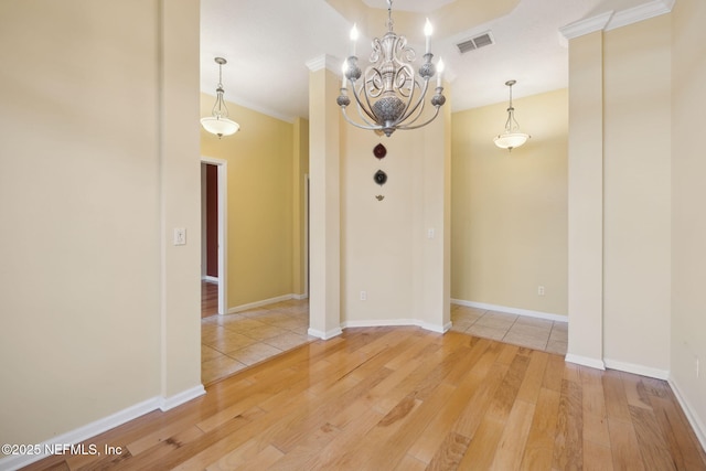 empty room featuring a notable chandelier and hardwood / wood-style flooring