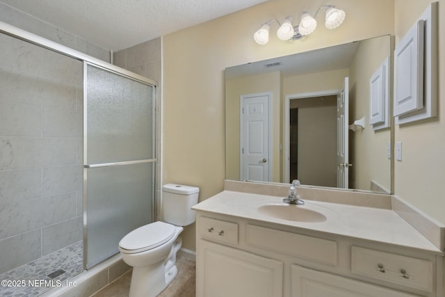 bathroom featuring walk in shower, vanity, toilet, and a textured ceiling