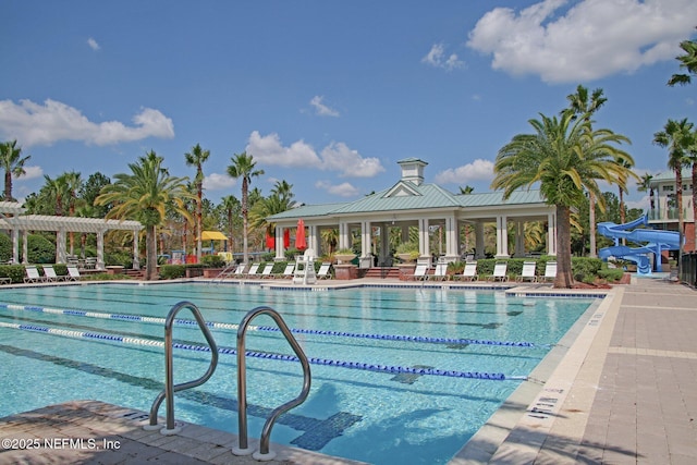 view of swimming pool featuring a water slide and a pergola