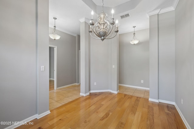 829 Songbird Dr, Orange Park, FL 32065 - unfurnished dining area with baseboards, an inviting chandelier, ornamental molding, light wood-style floors, and visible vents