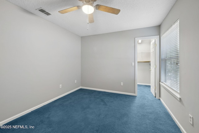 829 Songbird Dr, Orange Park, FL 32065 - unfurnished bedroom featuring visible vents, a walk in closet, carpet flooring, and a textured ceiling