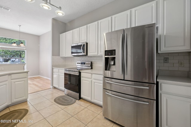 829 Songbird Dr, Orange Park, FL 32065 - kitchen featuring light tile patterned floors, light countertops, white cabinets, visible vents, and appliances with stainless steel finishes