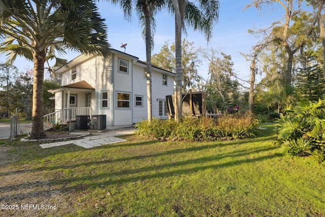 view of property exterior with a lawn and central AC