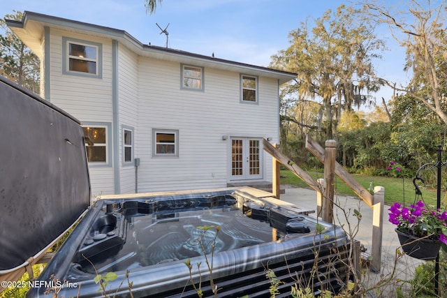 rear view of house featuring a patio, french doors, and a hot tub