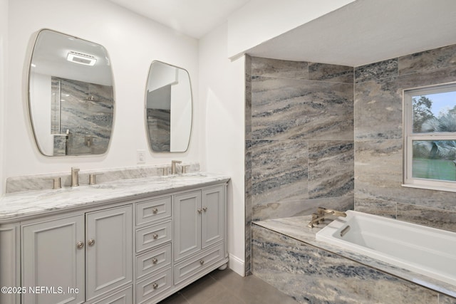 bathroom with tiled bath, tile patterned floors, and vanity