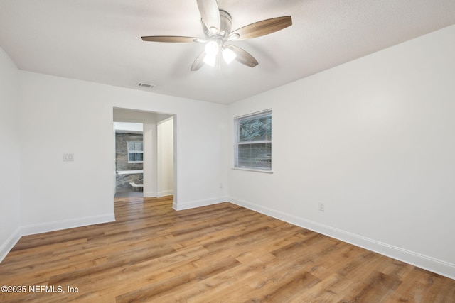 unfurnished room featuring ceiling fan, light wood-type flooring, and a textured ceiling