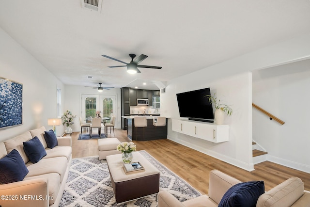 living room with light wood-type flooring and ceiling fan