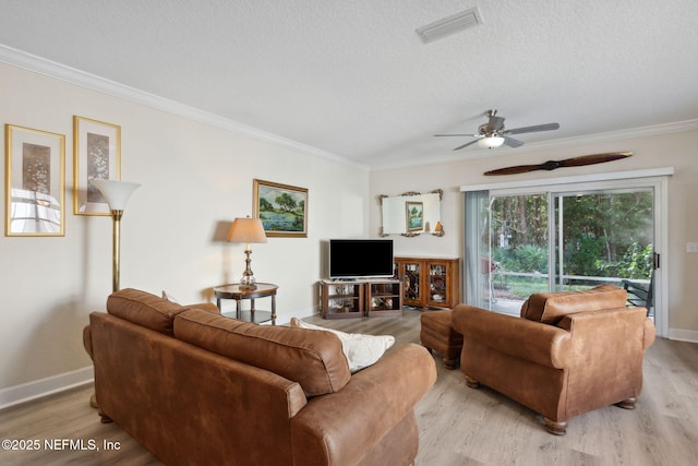 living room featuring crown molding, ceiling fan, a textured ceiling, and light wood-type flooring