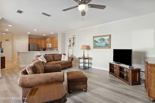 living room featuring crown molding, ceiling fan, light hardwood / wood-style flooring, and a textured ceiling