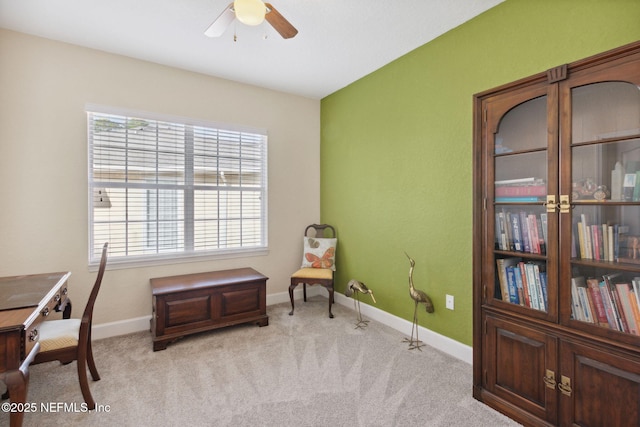 living area with light carpet and ceiling fan