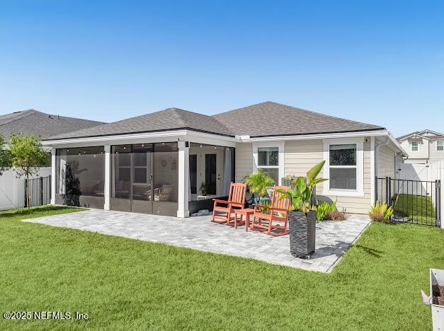 back of house with a yard, a patio, and a sunroom