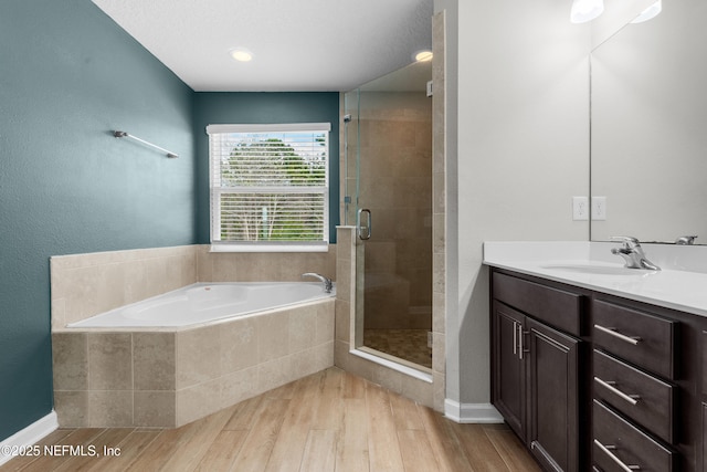 bathroom featuring vanity, hardwood / wood-style flooring, and separate shower and tub