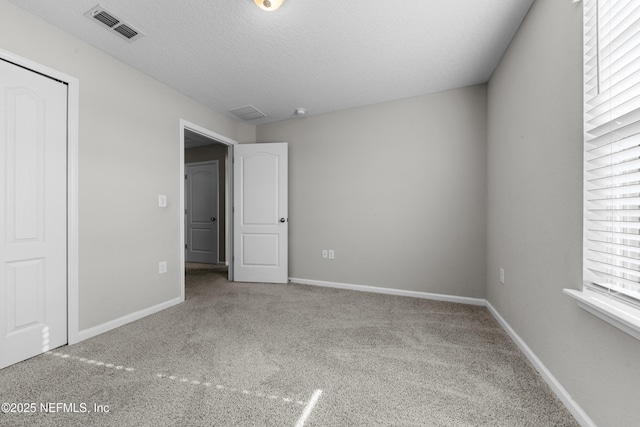 unfurnished bedroom featuring a textured ceiling and carpet flooring