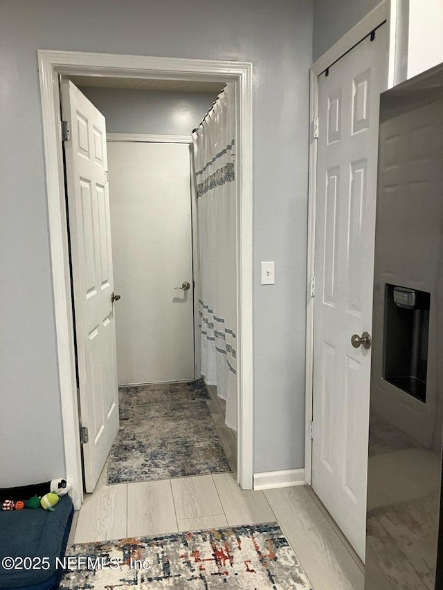 full bath with curtained shower, a washtub, baseboards, and wood tiled floor