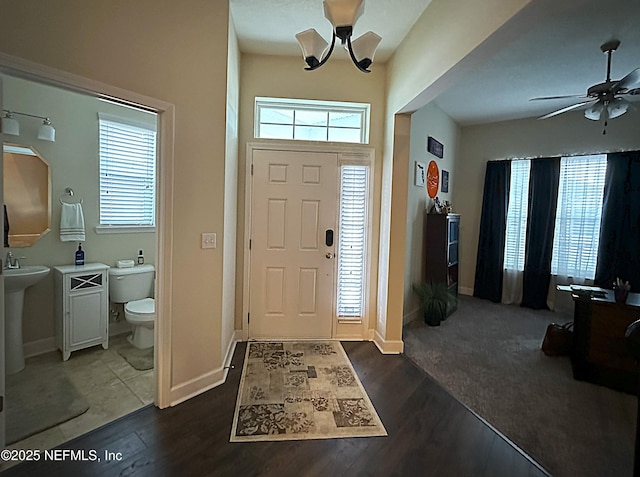 foyer featuring a ceiling fan, dark wood-type flooring, and a healthy amount of sunlight