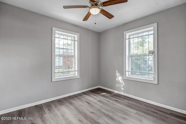 unfurnished room with hardwood / wood-style floors, a healthy amount of sunlight, and ceiling fan