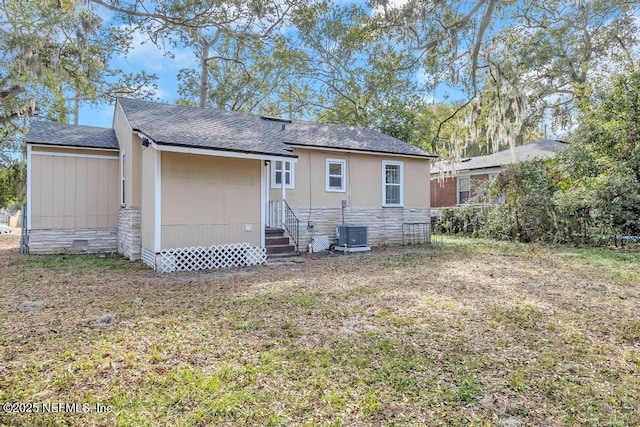 rear view of house featuring a yard and central AC unit