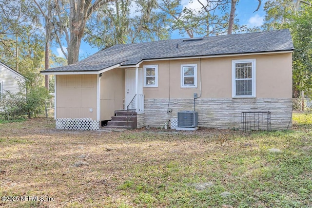 rear view of property with a yard and central AC unit