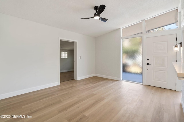 foyer entrance featuring a textured ceiling, ceiling fan, and light hardwood / wood-style flooring